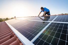 Man putting solar panels on a roof